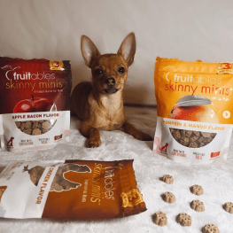 Dog lying down looking at camera with Fruitables treats